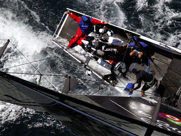 03_0183D ©Th.Martinez - Auckland (NZ) . America's Cup 2003. 15th February 2003. Day 1..Alinghi (SUI 64) vs Team NZ (NZL 82) .NZL 82 in first minutes of Race 1 before retiring on damage. Alinghi 1- Team NZ 0 .Matt Mitchell (Team NZ midbowman) bailing water out of NZL 82. .