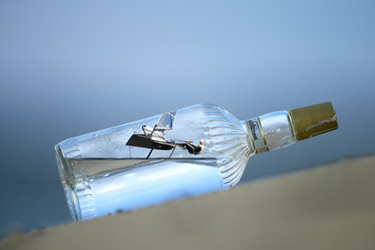 Photomontage.  Simon Payne (GBR) flying Moth in a bottle.