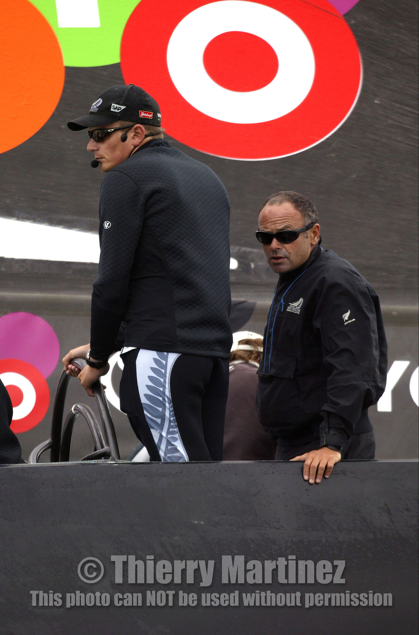 03_0244D ©Th.Martinez - Auckland (NZ) . America's Cup 2003. 20th February 2003. Day 4 Cancelled..Alinghi (SUI 64) vs Team NZ (NZL 82) .Team NZ's skipper Dean Barker at the helm of NZL 82, with frenchman Bertrand Pace (Tactician, on place of Hamish Pepper) for first time on board for America's Cup. Bertrand Pace is the first French sailor to race in n America's Cup match and is the helmsman of NZL 81. The race had been cancelled for wind not enough stable. Race 4 should start on Saturday 22th February...