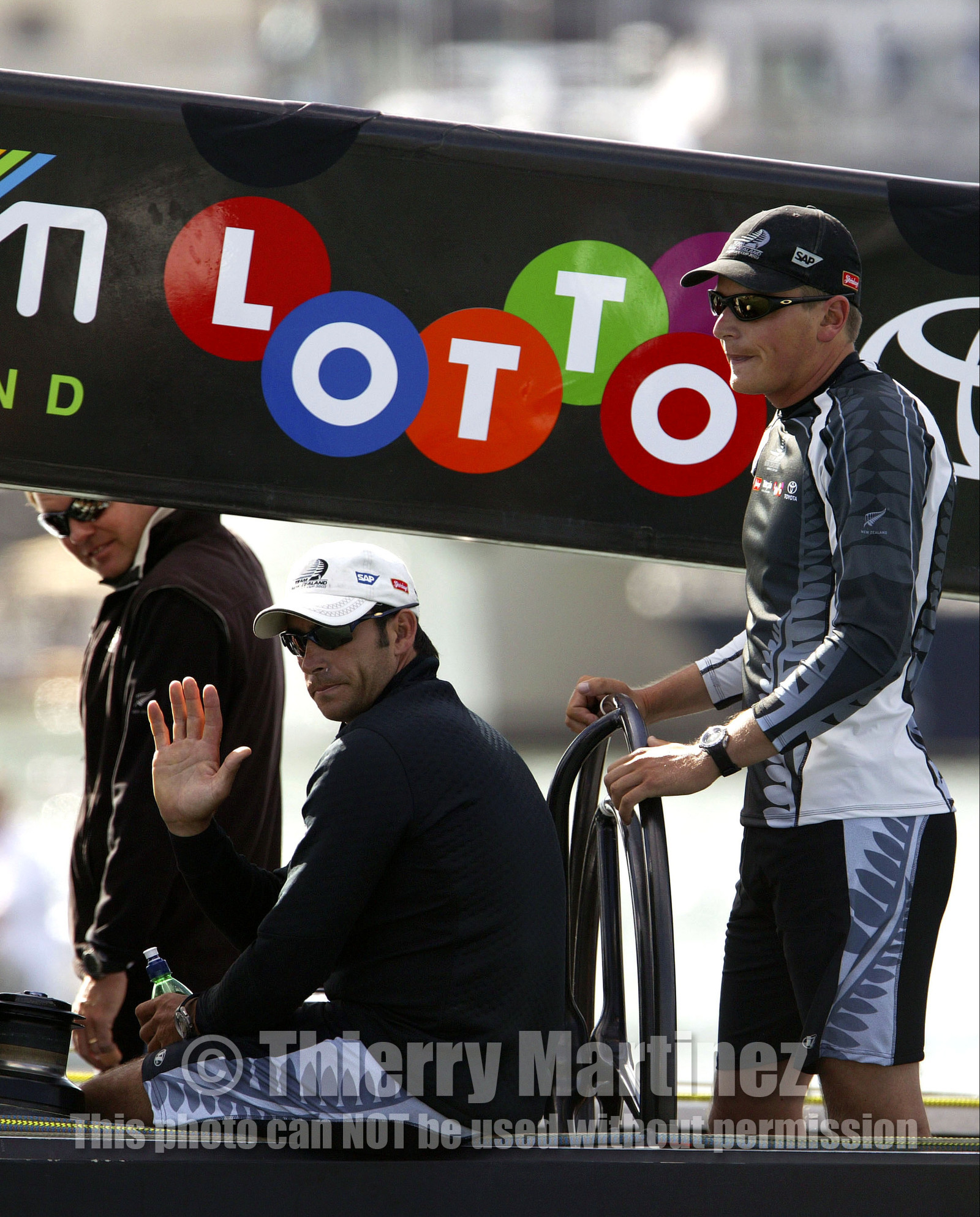 03_0150D ©Th.Martinez - Auckland (NZ) . America's Cup 2003. 15th February 2003. Day 1..Team NZ  NZL 82 leaving Vidauct Harbour to defend 31st America's cup against Challenger Team Alinghi in first race..Dean Barker Team NZ 's skipper at the helm and Hamish Pepper  , tactician, next to him waving to Team NZ fans.